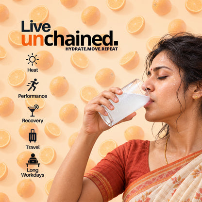 Woman drinking a glass of Unchained Orange electrolyte drink mix for everyday hydration
